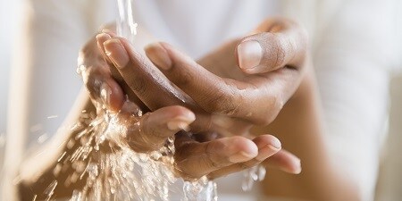manos bajo agua del grifo
