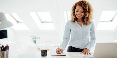 Mujer escribiendo notas en una oficina
