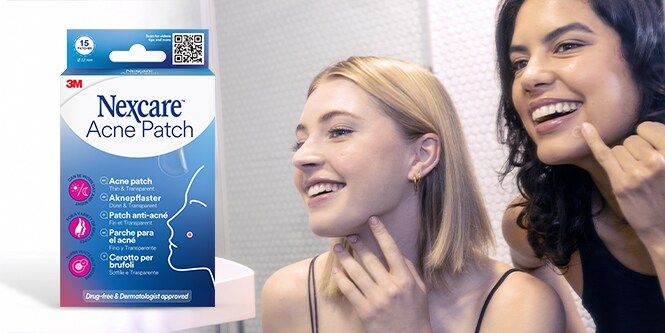 Una mujer señalando sus mejillas cubiertas con un discreto parche para el acné Nexcare™
