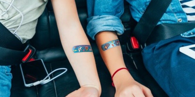 niños sentados en un coche con tiras de colores en los brazos
