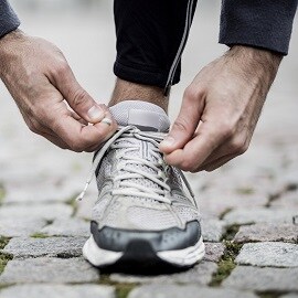 Hombre atándose los cordones