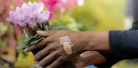 Mujer recogiendo flores con una tira impermeable en la mano
