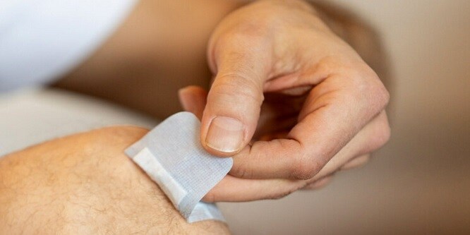Hombre quitando una tira adhesiva Nexcare
